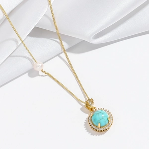 Close-up of gold flower necklace with turquoise stone, baroque pearl and zircon details