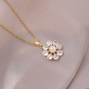 Elegante goldene Blumenhalskette mit Perle und acht funkelnden Strasssteinen auf Satin