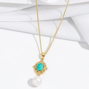 Détail du collier de perles baroques avec pendentif turquoise et cadre fleuri doré