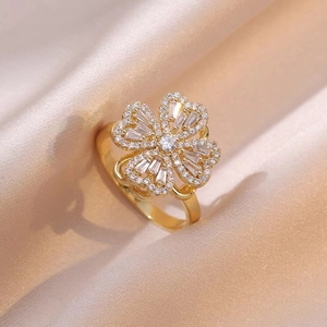 Detailaufnahme eines goldenen Blumenrings mit Zirkonia-Steinen auf champagnerfarbener Seide