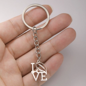 Detail eines Schlüsselanhängers aus Edelstahl mit LOVE-Schriftzug und hohlem Football-Anhänger