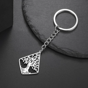Macro detail of silver stainless steel keychain featuring a tree of life hollow pendant