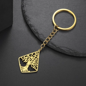 Detail of tree of life镂空pendant in golden finish on a dark stone background
