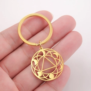 Detailed close-up of a golden geometric keychain featuring a hollow triangular circle design