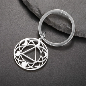 Macro detail of geometric cutout keychain with triangular pattern on stone background