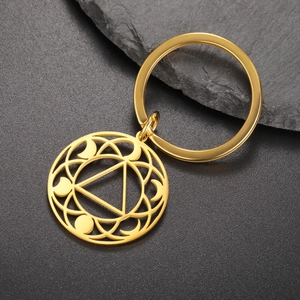 Detailed close-up of golden hollow keychain with geometric triangle and moon pattern