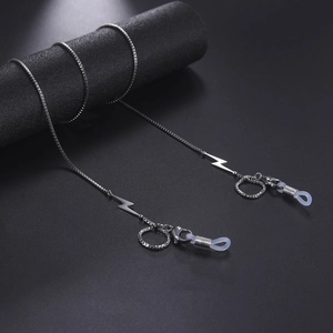 Macro shot of silver stainless steel eyewear chain featuring lightning bolt charms