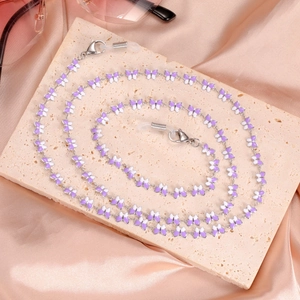 Detail of purple and white butterfly enamel glasses chain with lobster clasps on satin
