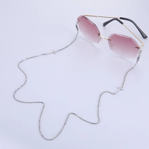 Détail de lunettes de soleil sans monture avec verres dégradés et chaîne à croix