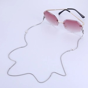 Close-up of frameless gradient sunglasses with silver lightning charm eyeglass chain
