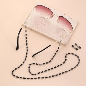 Details einer randlosen Sonnenbrille mit rosa Verlauf und schwarzer Perlenkette