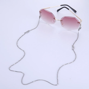 Detailed view of silver box chain with mountain pendants on rimless gradient sunglasses