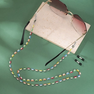 Detail view of rimless gradient sunglasses with colorful enamel butterfly chain accessories