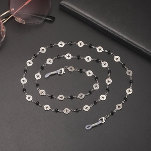 Chaîne de lunettes argentée avec motifs d'étoiles et fermoir sur fond noir mat