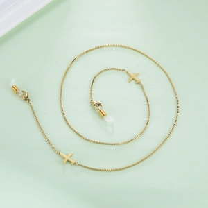 Détail de la chaîne de lunettes dorée en acier avec pendentifs avion et attaches en caoutchouc