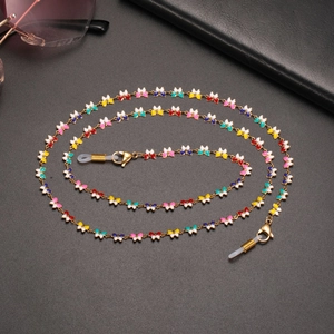 Close-up of colorful butterfly eyeglass chain with golden lobster clasps on black background