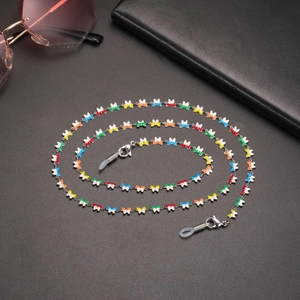 Detail view of colorful butterfly eyewear chain with silver links on black background