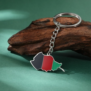 Titanium steel Afghanistan map keychain with colorful enamel dripping on rustic wood surface