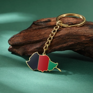 Titanium steel Afghanistan map keychain with gold finish and flag colors on wood