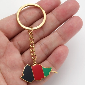 Detailed close-up of golden Afghanistan map keychain with black red green enamel stripes