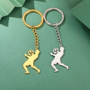 Porte-clés footballeur en acier inoxydable poli en or et argent sur un fond vert artistique