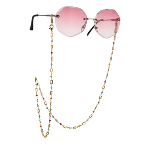 Rosafarbene Sonnenbrille mit bunter Perlen-Goldkette und Büroklammer-Gliedgeometrie
