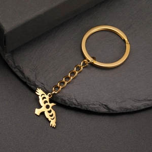 Close-up of golden stainless steel hollow eagle pendant on a black stone background