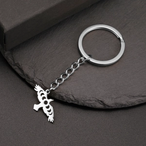 Detailed shot of silver raven keychain with moon phase cutouts on a dark stone background