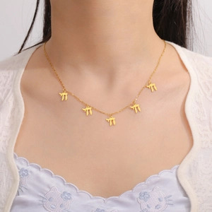 Detailweergave van een gouden RVS ketting met vijf Chai-bedeltjes gedragen door een model