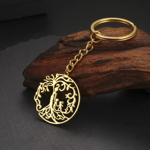 Détail du porte-clés doré avec l'arbre de vie et silhouettes de parents et enfants