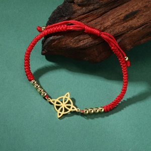 Dettaglio del braccialetto in corda intrecciata rossa con nodo di strega dorato e perle