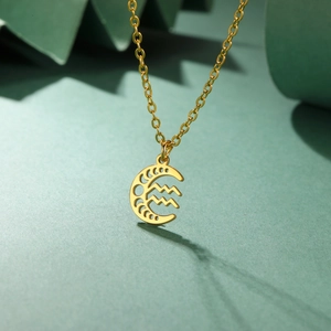 Collier lune dorée avec pendentif signe du zodiaque Verseau sur fond vert élégant