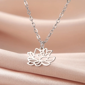 Silberne Lotusblume Halskette aus Edelstahl auf elegantem Seidenstoff Hintergrund