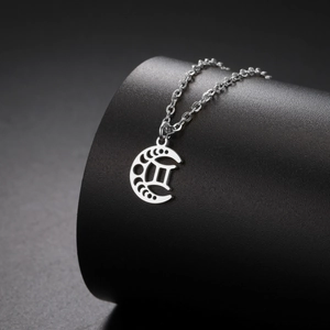 Vue macro détaillée du pendentif Gémeaux en acier inoxydable argenté avec croissant de lune