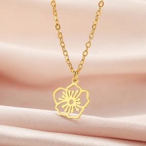 Nahaufnahme der goldenen hohlen Blumenkette auf weichem rosa Seidenhintergrund