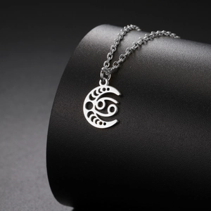 Détail macro du pendentif lune argenté avec signe du zodiaque Cancer évidé sur support