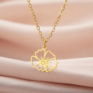 Nahaufnahme der goldenen Blumen-Halskette auf elegantem rosafarbenem Seidenhintergrund