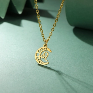 Détail d'un pendentif lune zodiaque Lion sur une chaîne croisée avec finition dorée