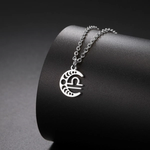 Détail du pendentif croissant de lune avec le symbole de la Balance en acier inoxydable