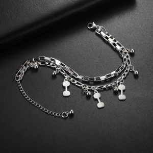 Detail view of triple-layered stainless steel bracelet with bone charms and lobster clasp