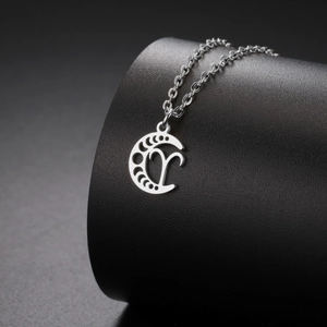 Gros plan du pendentif croissant de lune en acier inoxydable avec le symbole du Bélier
