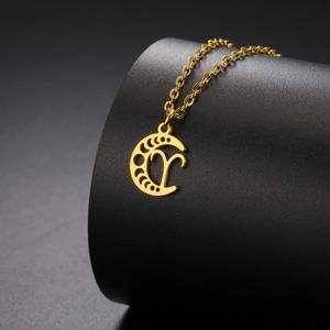 Détail macro du pendentif croissant de lune doré avec le signe du zodiaque Bélier sur collier