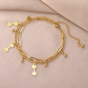 Detail of gold double-layered bracelet with dumbbell pendants and lobster clasp