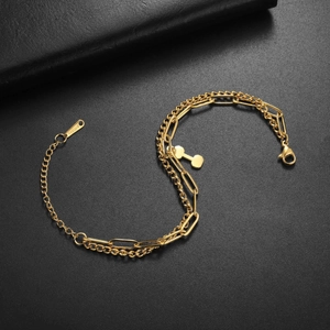 Close-up of golden stainless steel dumbbell charm and dual-layer link chain bracelet