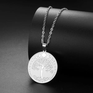 Detalle del colgante árbol de la vida plateado con silueta de mujer y símbolos celestes