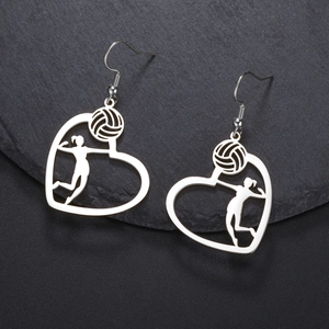 Detailed view of heart-shaped volleyball player silhouette earrings on a black stone surface