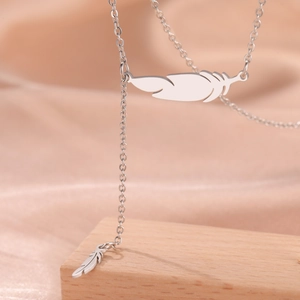 Macro shot of polished stainless steel feather pendants on a delicate link chain