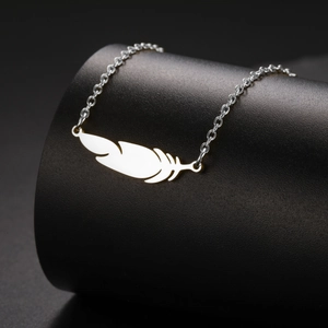Polished silver feather pendant necklace made of stainless steel on black display stand