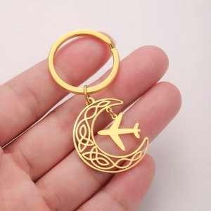 Golden stainless steel moon keychain with Celtic knot pattern and small airplane pendant