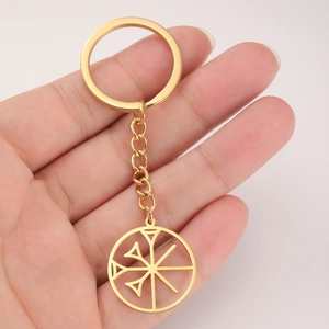 Hand holding a gold stainless steel keychain with a Sumerian cuneiform round pendant